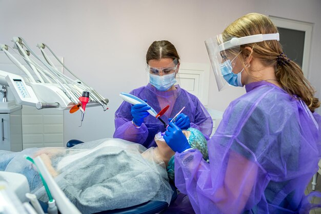 Dentist lies in a special chair where the dentist and assistant will perform teeth whitening