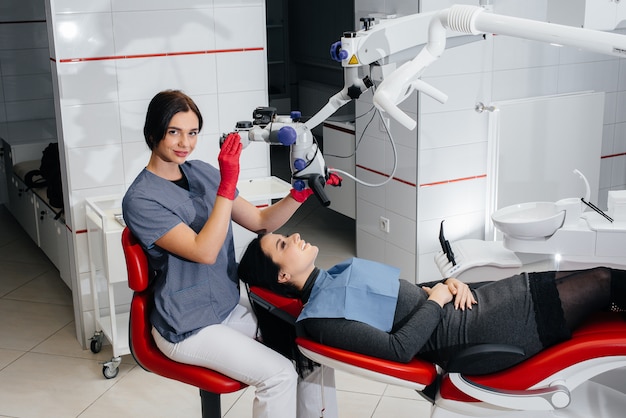 The dentist looks through a microscope and performs surgery on the patient