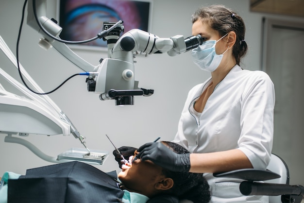 Dentist makes surgery to woman, visit in dental clinic.