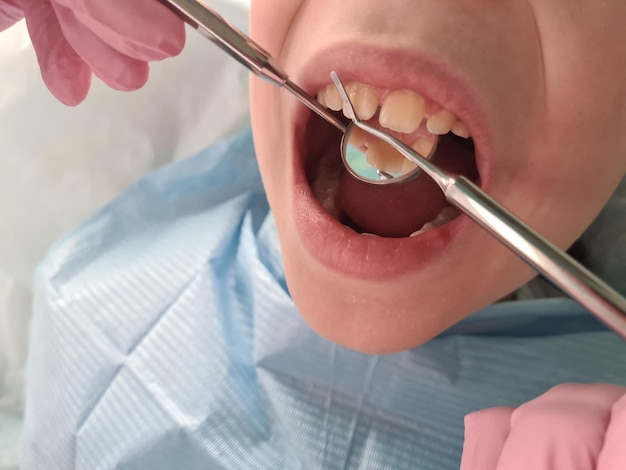 Dentist orthodontist in dental clinic treats child teeth