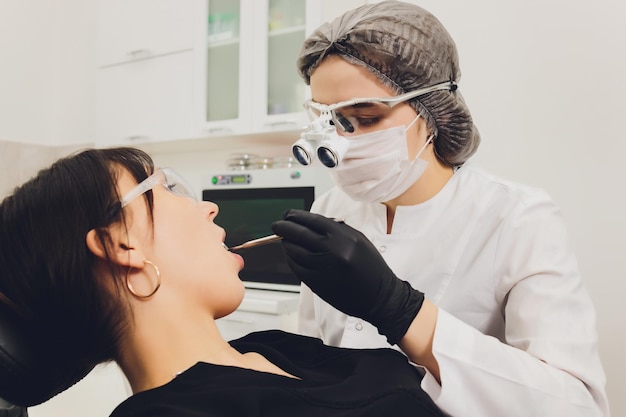 Dentist and patient choosing treatment in a consultation with medical equipment in the background