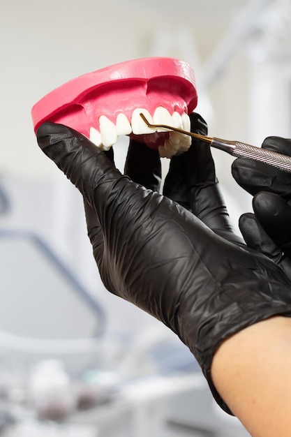 Dentist's hands with layout of human jaw and midical tool