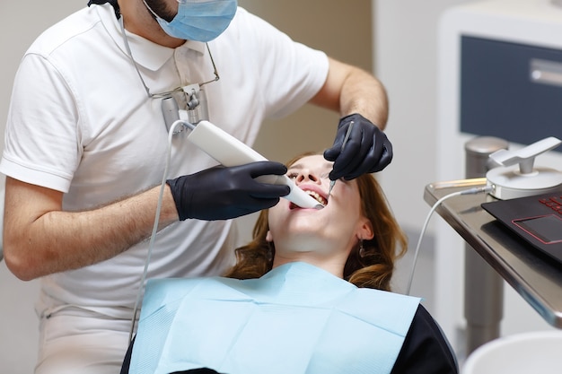 The dentist scans the patient's teeth with a 3d scanner.