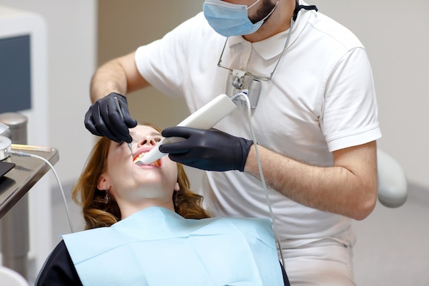 The dentist scans the patient's teeth with a 3d scanner.