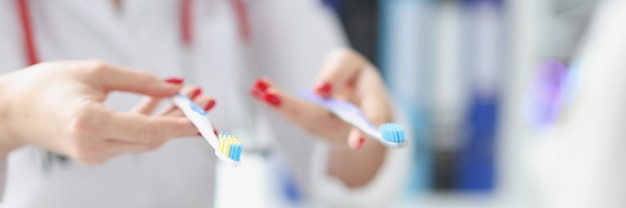 Dentist shows two toothbrushes to patient best toothbrush concept