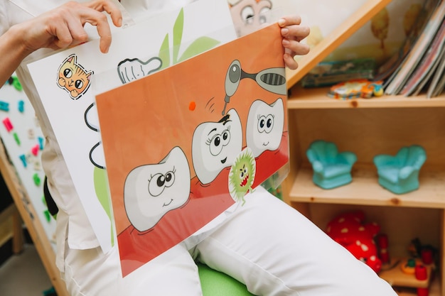 Dentist tells children how to brush their teeth. Caries prevention, pediatric dentistry, milk teeth hygiene concept