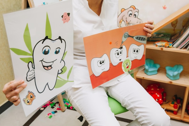 Dentist tells children how to brush their teeth. Caries prevention, pediatric dentistry, milk teeth hygiene concept