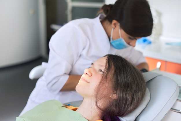 Dentist treating teeth to a patient in dental clinic