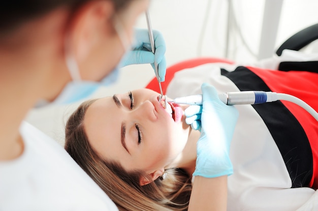 Dentist treats teeth to a patient - a beautiful young girl