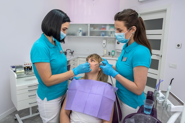 Dentist woman talking to her patient about the treatment of her teeth