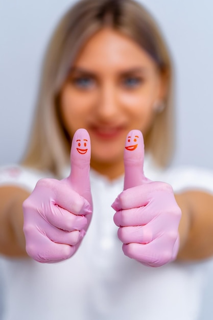 Dentist woman with pink gloves Showing cool sign Red smiles on thumbs