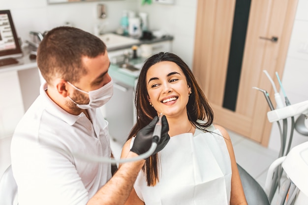 Dentist working in dental clinic with female patient in the chair