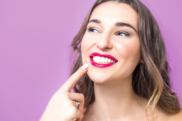 Dentistry concept. Beautiful young woman smiling, showing healthy white teeth, red lipstick. 