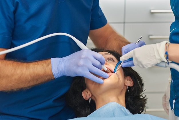 Dentists performing a dental cleaning.