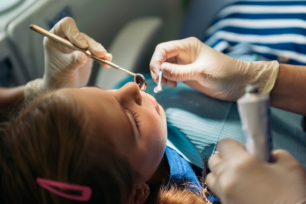 Dentists with a patient during a dental intervention to girl. Dentist  Concept