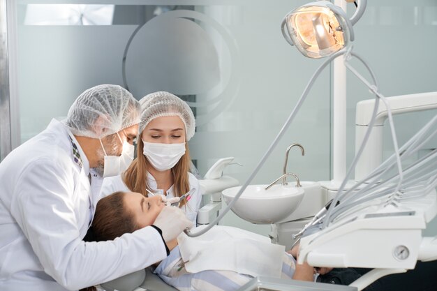 Dentists working with patient in clinic.