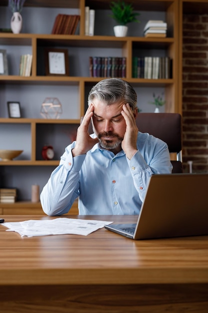 Depressed adult man calculating monthly expenses Mad grayhaired businessman feels frustrated about high bills bank debt tax invoice credit payment Financial problems crisis bankruptcy