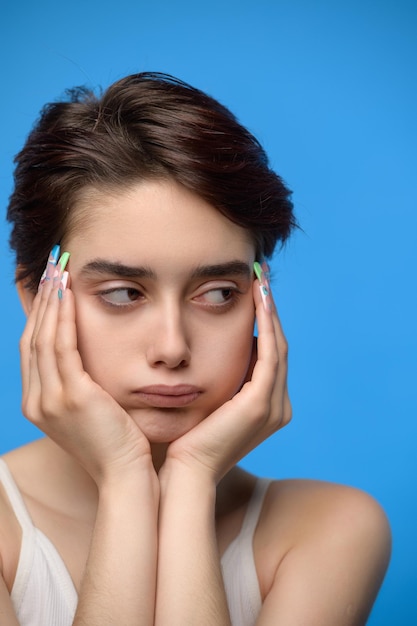 Depressed bored teenage girl at blue background