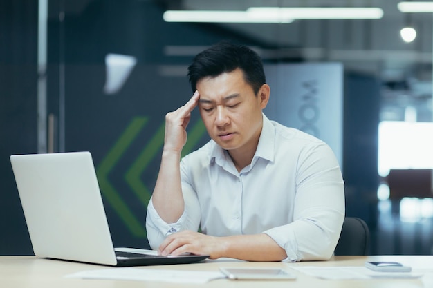 Depressed businessman boss working in modern office thinking asian businessman sad thinking about