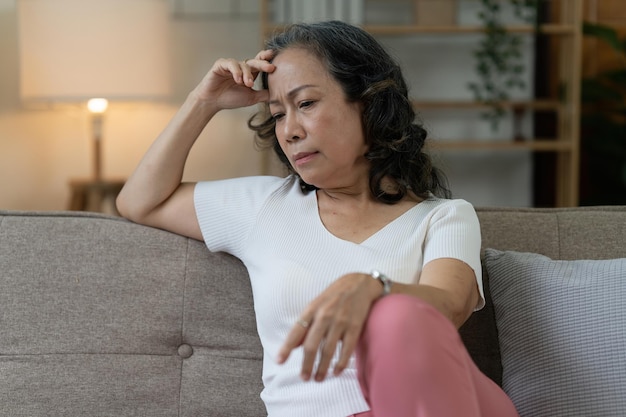 Depressed Elderly Asian woman sitting alone at home Retired woman concept