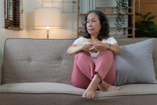 Depressed Elderly Asian woman sitting alone at home Retired woman concept