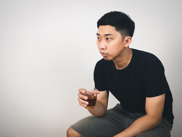 Depressed man hold glass of alcohol sitting feels hopeless