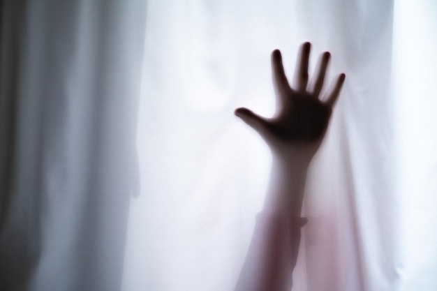 Depressed Man with mental problems hiding above the curtain