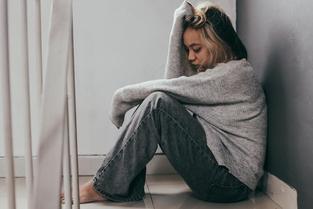 Photo depressed and sad young woman sitting alone at home