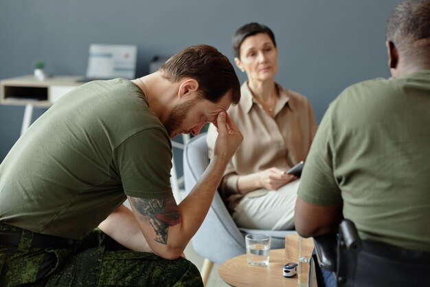 Photo depressed soldier resting head in hands