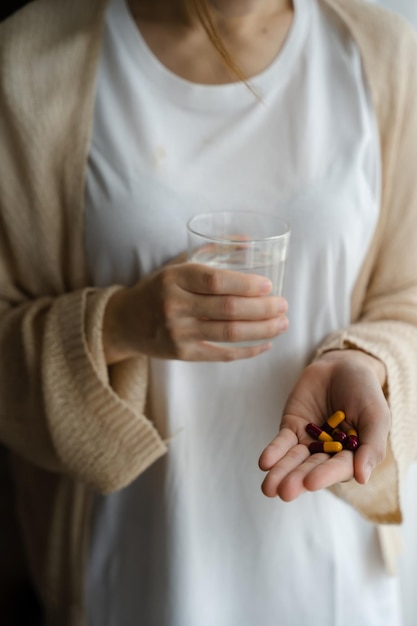 Depressed woman holding a glass of water suffering from headaches