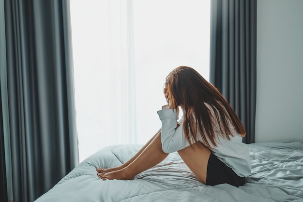 Depressed woman sitting in the bedroom