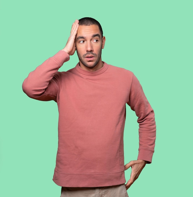 Depressed young man posing against background