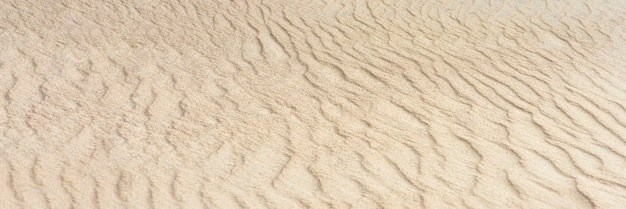 Desert sand dunes texture. Waves on the yellow sands of the desert. Close-up of a sandy beach.