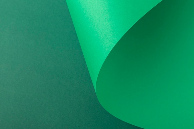 Design background of folded curl from green cardboard. Top view, flat lay.