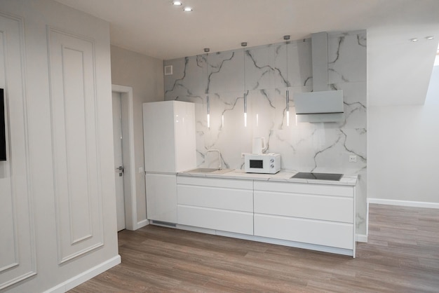 Design of the kitchen room in a light color with a table and appliances