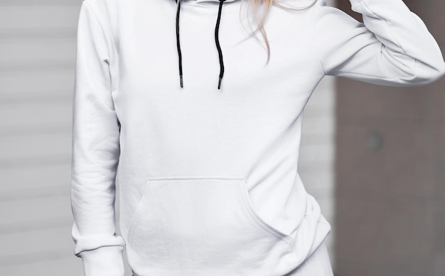 Design mockup for clothing logo A woman wears a white hoodie on the street