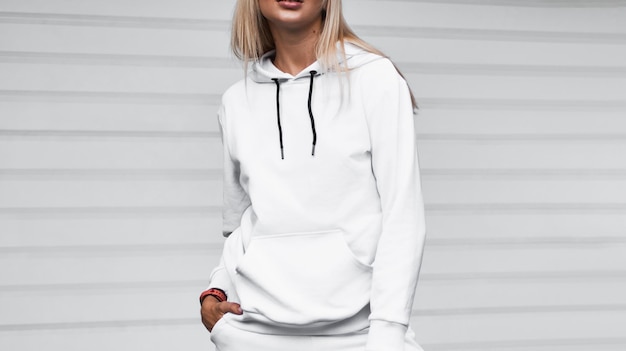 Design mockup for clothing logo A woman wears a white hoodie on the street