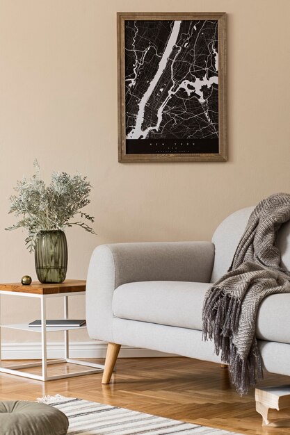 Design scandinavian home interior of living room with  map, stylish coffee table, gray sofa, plaid, pillow flower in vase and elegant personal accessories. Modern home staging.