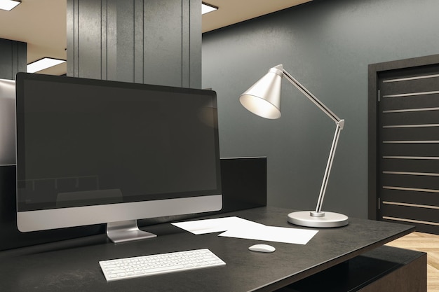 Designer desktop with black computer screen and lamp