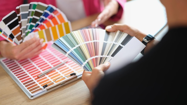 Designer helps client choose colors for project from variety buyer and seller agree on product