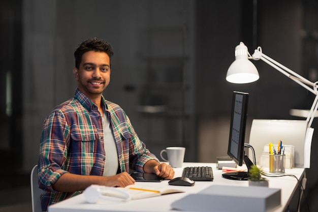 designer with computer working at night office