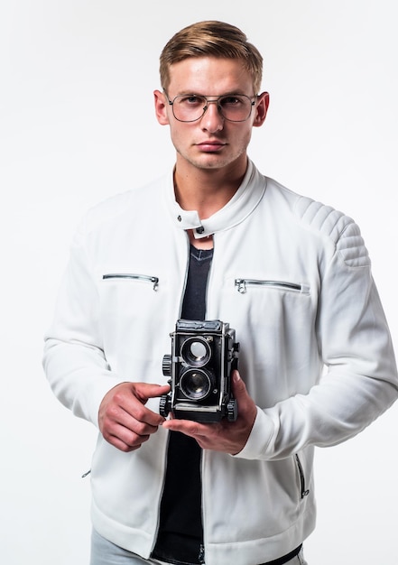 Desire meets new hobby. Handsome guy hold retro camera isolated on white. Young photographer wear glasses in casual style. Photography equipment. Hobby and lifestyle. Shooting session.