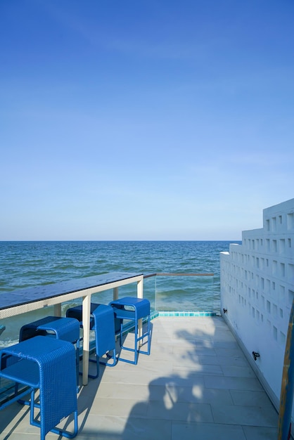 Desk and bar stool near swimming pool with sea background