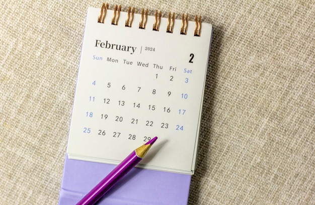 Desk calendar for February 2024 and on the table with copy space