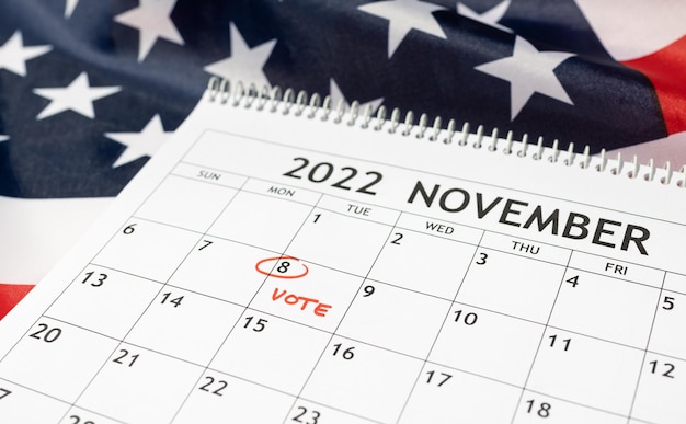 Desk calendar with November 8 2022 marked in red on USA flag background Vote day concept