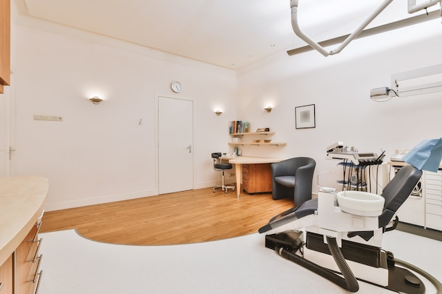 Desk and chair placed near professional dentistry equipment in office of modern clinic