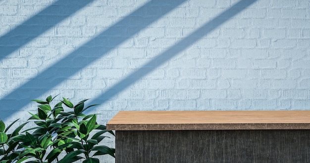 A desk in front of a white brick wall with a plant in the corner.