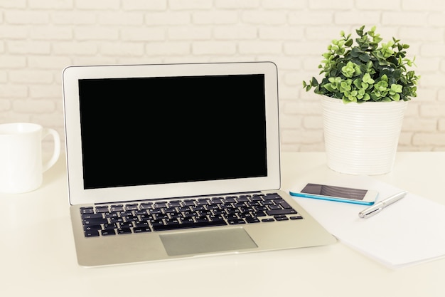 Desk table with smartphone and laptop with black screen and other office supplies, Copy space