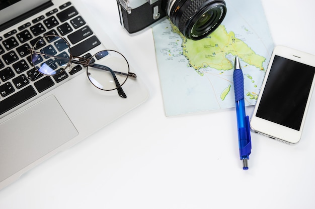 Desk with a notebook, telephone, camera, map, and planning a trip 