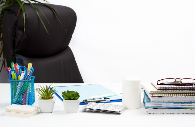 Desk with stationery and empty brown leather chair, white background